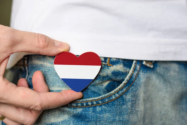 私はオランダの愛国者です 男の手にハートの形をしたオランダ国旗の木のバッジ — ストック写真