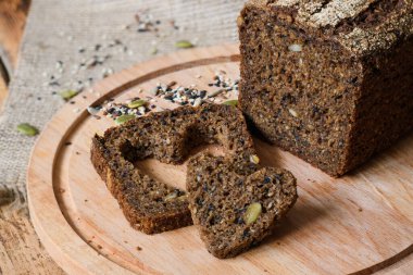 Kalp şeklinde bir dilimin yanında taze, sağlıklı çavdar ekmeği. Sağlıklı gıda konsepti. Üst görünüm, bir dilim ekmeğe odaklan.