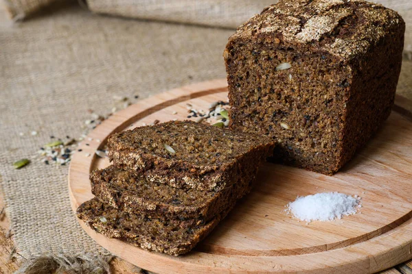 Tahtaya yakın çekim ekmek ve beyaz tuz. Bir dilim ekmeğe odaklan..