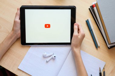 Vladimir, Rusya - Ocak 2022: YouTube uygulaması bir öğrencinin elinde bulunan bir tablet üzerinde ders için. Yakın çekim, üst görünüm.