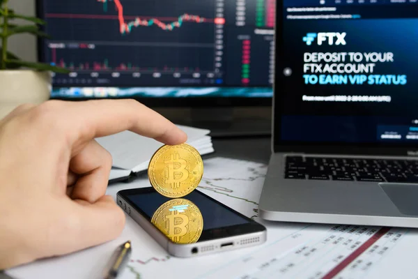 Vladimir, Rusya - Ocak 2022: FTX şifreli döviz web sitesi ile bilgisayarların arka planında Bitcoin madeni para. Madeni paraya odaklan..