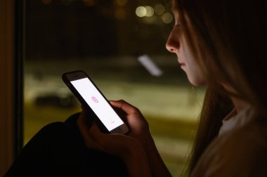 Vladimir, Rusya - Ocak 2022: Instagram sosyal ağ uygulaması bir kızın elinde akıllı bir telefonla. Logoya seçici odaklanma.