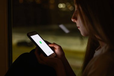 Vladimir, Rusya - Ocak 2022: İletişim için Whatsapp habercisini kullanmak. Elinde bir başvuru formu olan akıllı bir telefon. Logoya seçici odaklanma.