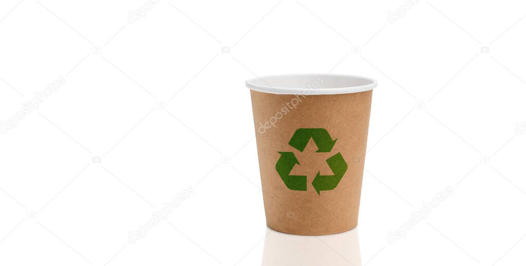 Empty paper cup for coffee made from biodegradable brown paper on a white background with a green recycling sign. The concept of using biodegradable materials to protect the environment.