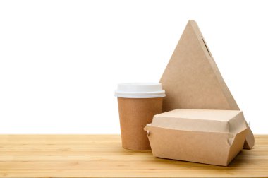 Yemek teslimatı konsepti. Tahta bir masada kağıt kaplar (pizza, hamburger, kahve kağıdı). İzole edilmiş arkaplan.