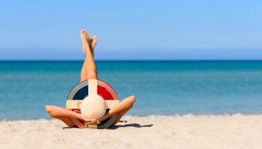 Plajda saman şapkalı Dominik bayrağı renginde ince bir kız. Dominik Cumhuriyeti 'ndeki bir tatil beldesinde mükemmel tatil kavramı. Şapkaya odaklan..