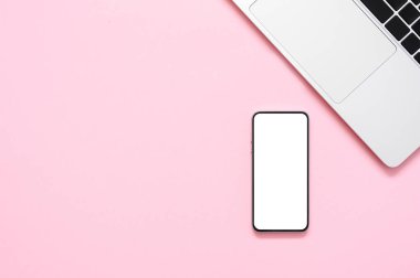 Pembe kağıt arka planda boş ekran akıllı telefonun ve dizüstü bilgisayarın üst görüntüsü. Düz yat, boşluğu kopyala, taklit et.