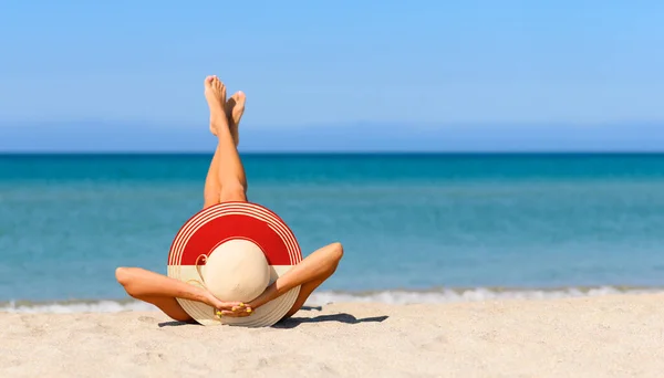 インドネシアの旗の色でわらの帽子のビーチで細い日焼けした女の子 インドネシアのリゾート地での完璧な休暇の概念 帽子に集中しろ — ストック写真