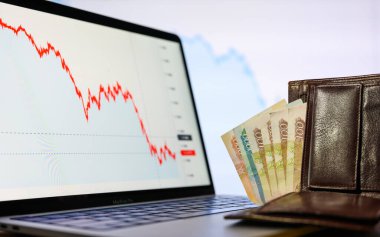 Vladimir, Rusya - Şubat 2022: Cüzdandaki Rus parası azalan mali tabloların arkaplanına karşı. Rusya 'daki kriz konsepti ve paranın değer kaybı. Seçici para odaklı.