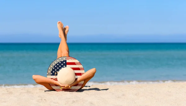 米国の国旗の色でわらの帽子のビーチで細い女の子 アメリカのリゾート地での完璧な休暇の概念 帽子に集中しろ — ストック写真