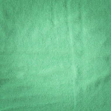 Doğal yün dokusundan örülmüş yeşil, rahat bir kazak.