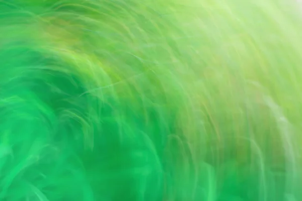 Amazing green nature in motion. Green and blue abstract defocused motion blurred background.