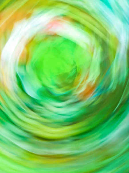 Defocused green motion blur swirling background. Colourful green vortex blur background.