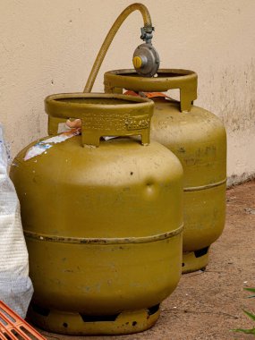 Two golden cooking gas cylinders outside the house