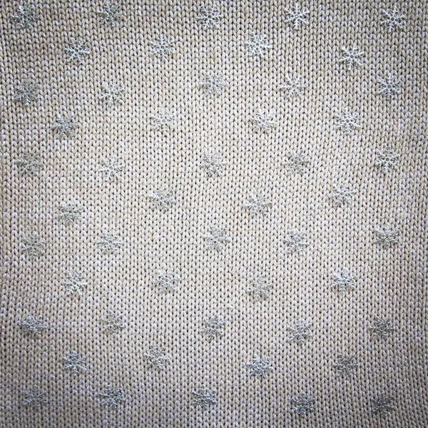 Knitted background with snowflakes. Knitted fabric with sequins with snowflakes. — Stock Photo, Image