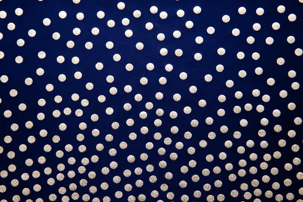 Pontos dourados num fundo escuro. Fundo azul escuro com bolinhas, textura de tecido com um padrão. — Fotografia de Stock