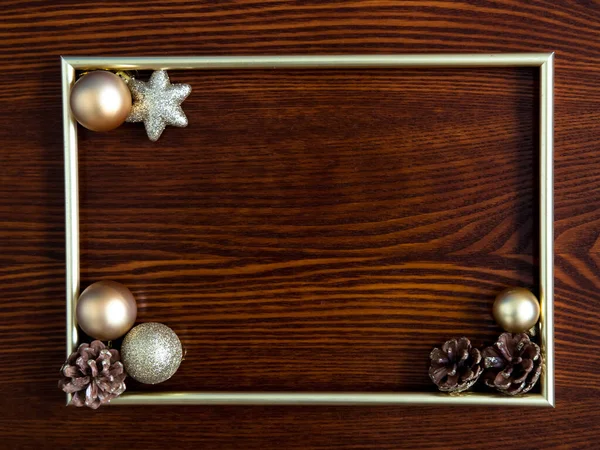 Фоторамка, золотые украшения на деревянном фоне. Рождество, зима, новый год. Плоская кладка, вид сверху, копировальное пространство. — стоковое фото