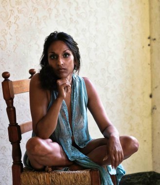 Hint kökenli güzel bir model. Çok şehvetli bir fotoğraf çekimi için poz veriyor. İç çamaşırı ve sabahlıkla.