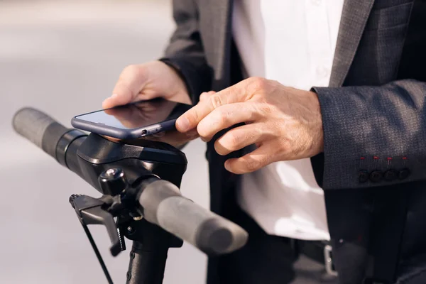 Nierozpoznawalny człowiek wziąć wynajem skuter elektryczny NFC bezstykowy szafka na rowerze w dzieleniu parking, aplikacja telefon turystyczny. Dzielenie się ekologicznym transportem w mieście — Zdjęcie stockowe