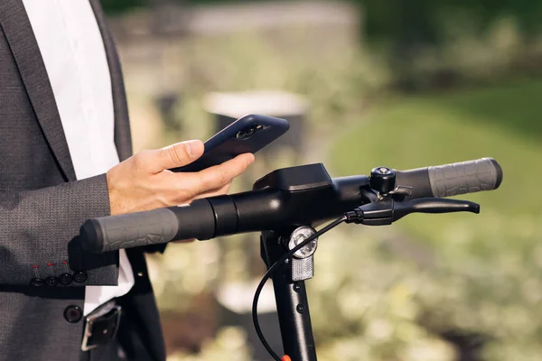 Tanınmayan turist işadamı elektrikli scooter NFC kontaksız dolap kullanıyor. Adam cep telefonu uygulaması kullanarak elektrikli scooter kiralıyor. Kiralık scooter için telefon başvurusu. Ekolojik Şehir Taşımacılığı — Stok fotoğraf