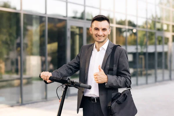 Beyaz iş adamının portresi elektrikli scooter 'a yaslanıp kameraya bakıyor. Dışarıdaki araçta stil sahibi adam. Çevre dostu modern şehir ulaşımı. Ekoloji ve kentsel yaşam tarzı — Stok fotoğraf