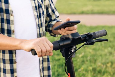 Turist otoparkta, turist telefonu uygulamasında Electric Kick scooter kullanıyor. Şehirde yeni bir ortaklık projesi, ekolojik ulaşım başladı. Çevre dostu ulaşım