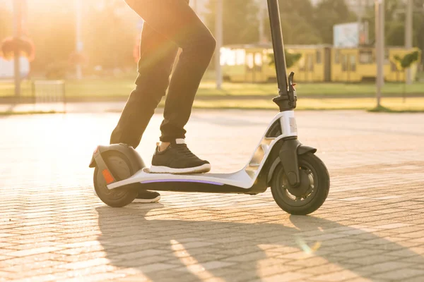 Modern yollarla işe giderken elektrikli scooter kullanan siyah ayakkabılı hippi bacaklar. Hızlı sürüşlü elektrikli taşıma. E-scooter sürücüsü, insan sürüşü paylaşımı veya kişisel çevre taşımacılığı — Stok fotoğraf
