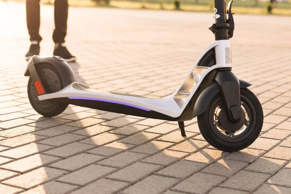 Een man die naar zijn e-scooter loopt. Een toerist neemt een elektrische scooter. Volwassen man op elektrische scooter. Knappe vent rijdt op scooter gadget op straat in de ochtend. Milieuvriendelijk vervoer — Stockfoto