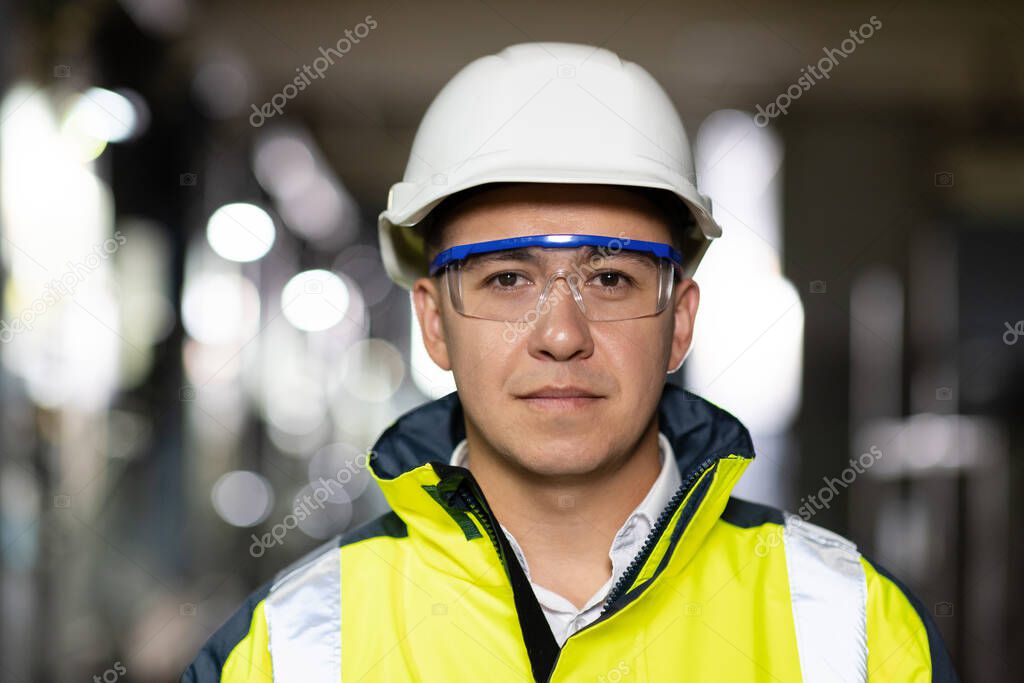 Professional Confident Serious Engineer Looking at Camera, Wearing Safety Uniform and Goggles Standing at Heavy Industry Factory Ready to Manufacturing Works During Metal Welding by Staff