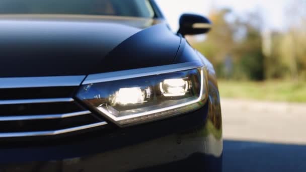 Feu avant de voiture clignotant d'urgence. Personne n'est là pour aider. Signal lumineux de secours, signal d'alarme. Nouvelle lampe frontale de voiture moderne. Lumière menée avant de voiture avec un arrière-plan flou — Video