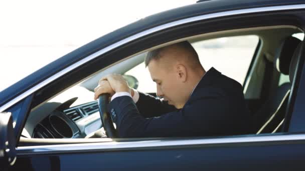 Side view of mature business man leaning her head on steering wheel while feeling tired after long distance riding. Concept of people, transport and exhaustion — Stock Video