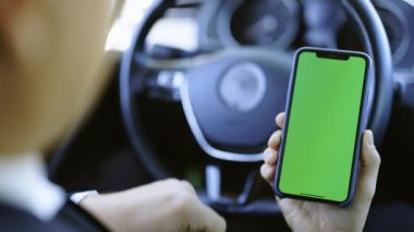 Erkek elinin dokunuşunu, kroma tuşlu yeşil ekranda kayışını içeriği izleyen akıllı telefon görüntüsü. Kadehler ve çağdaş insanlar konsepti. Dikey yeşil ekranlı telefonu tutan adamın elleri