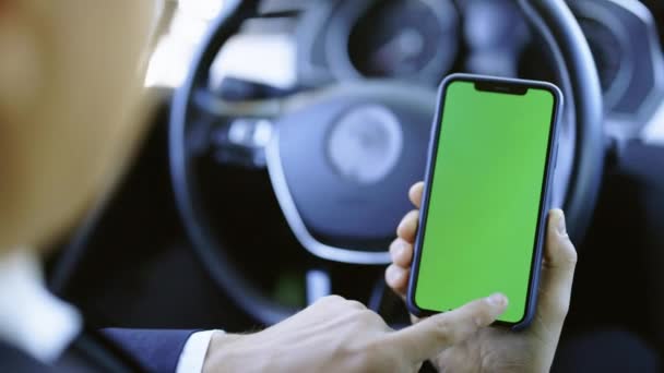 Man hand med hjälp av chromakey mobiltelefon med tom grön skärm i modern bil. Mockup pekskärm. Internetsökning. Rullande smartphone display närbild — Stockvideo