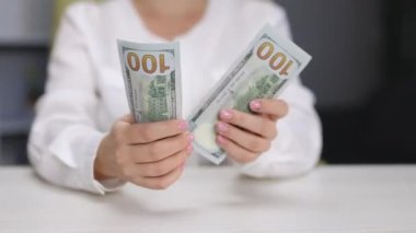 CU 'daki kadın 100 Amerikan doları sayıyor. Nakit para. Finans ve yatırım. 100 'lük banknotların döviz değişimi. Rüşvet ve yolsuzluk kavramı. Zengin iş ekonomisi