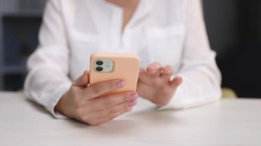 Kapalı bir iş kadını ev telefonunda mesaj yazıyor. Genç kız telefonda konuşuyor. Akıllı telefon kullanarak genç kadın ellerini kapat.