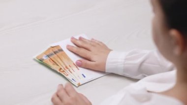 Zarftaki maaş, yolsuzluk konsepti. Masadaki zarf rüşveti, para banknotlarının nominal değeri 50 avro. Nakit para hesaplamaları. Beyaz zarf içinde Euro banknotları