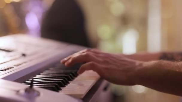 피아니스트는 피아노를 연주 한다. 로맨틱 한 분위기, 완벽 한 데이트. 피아노를 치고 노는 젊은이처럼 손을 잡으세요. 피아노 전자 건반으로 연주하는 남자 손 — 비디오