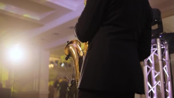Σαξοφωνίστας παίζει σε χρυσό σαξόφωνο. Ζωντανή παράσταση. Παίκτης σαξοφώνου παίζει σόλο σε πάρτι. Μουσικός παίζει alto σαξόφωνο σε συναυλία — Αρχείο Βίντεο