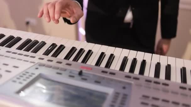 Pianista toca em belo sintetizador no palco em concerto. O músico toca um instrumento musical no palco do concerto. Sintetizador. Mãos masculinas a tocar piano. Homem toca dedos em chaves. — Vídeo de Stock