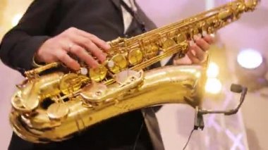 Caz grubunda solo çalan saksafoncu, hafif sahnede sahne alıyor. Konserde bandosu olan saksafoncu müzisyen. Müzik grubu şarkı söylüyor, sahne performansı sergiliyor.
