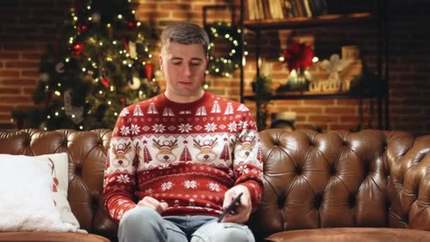 Portrait de joyeux caucasien jeune homme heureux souriant avec le visage surpris tapant sur le téléphone portable se sentant excité et heureux de gagner à la loterie de Noël. Concept de Noël. Miracle de vacances. Joyeux Noël. — Video