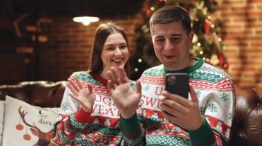 Aile, arkadaşlarına video iletişimi için mutlu Noeller diliyor. Çift, izolasyon sırasında aile ve arkadaşlarıyla görüntülü konuşma yapıyor. Arkadaşların video çağrısı ile sanal kutlama