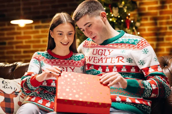 Christmas gift woman opening present with surprise sexy underwear laughing enjoying funny joke with boyfriend celebrating festive holiday at home