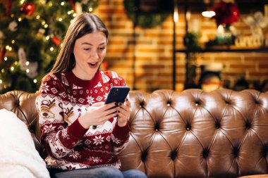 Mutlu gülüşler beyaz kadın akıllı telefon ekranına bakıyor, inanılmaz haberlerle mesaj alıyor, yeni yılı ya da Noel piyangosunu kutluyor. İnternet başarı kavramı