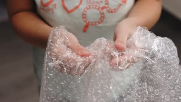 Девочка играет с пузырьковой пленкой. Девушка нажав пузырь упаковки заменяет прядильщик, слизь и лопнуть его. Успокаивает концепцию нервной системы — стоковое видео