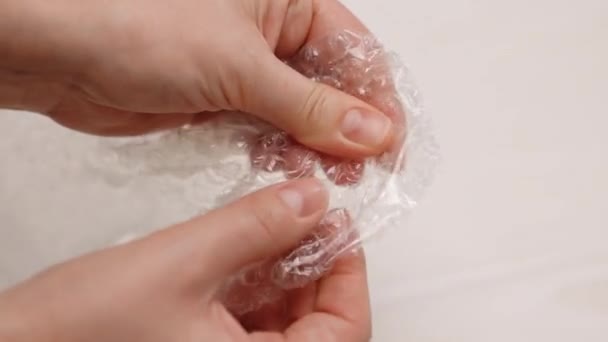 Bubble wrap menggantikan spinner, lendir dan pop itu. Jari-jari bermunculan gelembung dalam bungkus gelembung terapi anti-stres close-up selama karantina dan kuncian — Stok Video