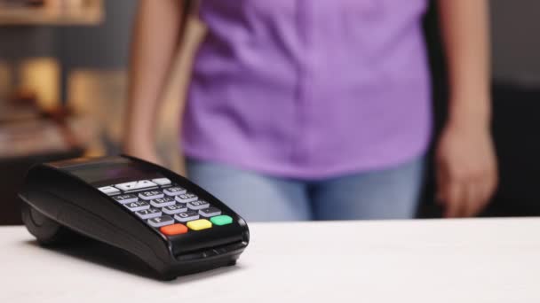 Closeup of female hands with pos-terminal of employee and cellphone. Pay by phone on electronic payment machine or card reader. E-money at cashless wallet. Client buys food order at coffee place. — стоковое видео