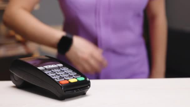Απρόσκοπτη πληρωμή με το έξυπνο ρολόι σας. Ασύρματη έννοια πληρωμής. Κοντινό πλάνο, γυναίκα που χρησιμοποιεί την τεχνολογία smartwatch cashless πορτοφόλι NFC για να πληρώσει την παραγγελία στο τερματικό τράπεζα. Πληρωμή κινητής τηλεφωνίας — Αρχείο Βίντεο