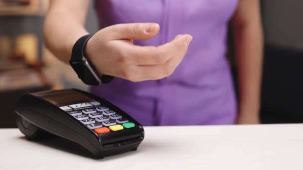 Ügyfél fizet NFC technológiával intelligens óra érintésmentes terminálon a modern kávézóban. Elektronikus pénz készpénz nélküli pénztárcában. Okosan fizetsz. A kovid koronavírus-zárlat után újra megnyitják az üzletet. — Stock videók