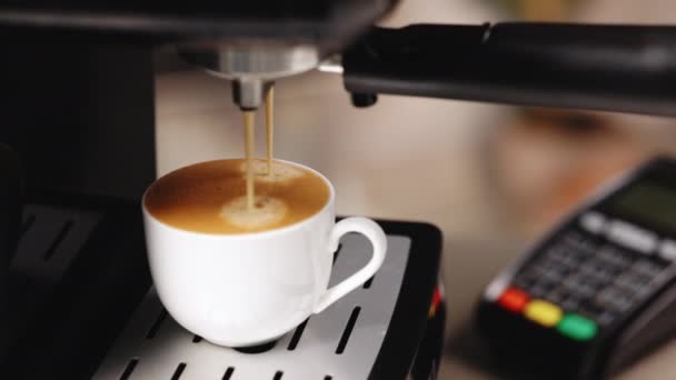 Process of making coffee by coffee machine into cup, espresso coffee coming out from an automated coffemaker machine. Beverage drink for breakfast. Coffeeshop with credit card machine terminal NFC — Vídeo de Stock
